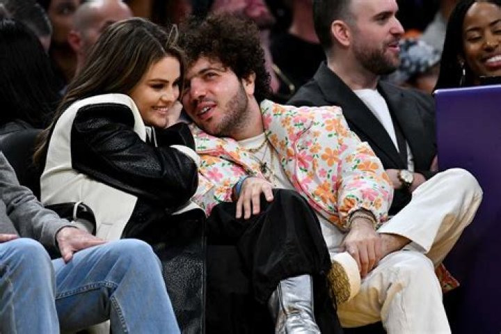 Selena Gomez embraces the power of pink in floral dress, long overcoat, and 60s-inspired hairstyle