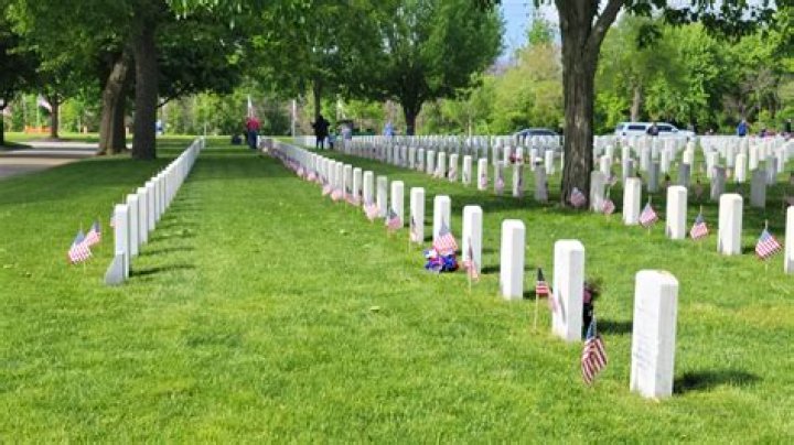 Volunteers place thousands of flags on veterans’ graves at National Cemetery